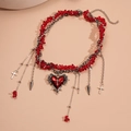 Detailed macro view of Gothic red heart pendant and cross charms on beaded necklace - Red