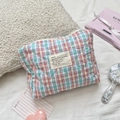 Vue détaillée de la trousse de maquillage matelassée aux motifs à carreaux pastel - Grille Orange