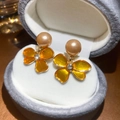 Gros plan détaillé de boucles d'oreilles pétales évidés avec perles champagne et strass - Style Fleur Café