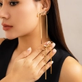 Polished gold bow earrings with snake chain tassels shown on model for elegant look - Snake Chain Bow Tassel Earrings / Gold