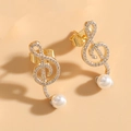 Elegante goldene Violinschlüssel-Ohrstecker mit Zirkonia-Besatz und weißer Perle - Musiknoten Perlenohrringe / Gold