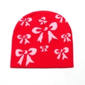 Detail van rode gebreide muts met roze strikpatronen en dikke thermische textuur - M (56-58cm) / Rood