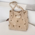 Dettaglio della borsa tote in velluto beige con motivi di orsi ricamati e texture morbida - Cachi