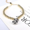 Detail of adjustable beaded bracelet with silver letter S charm and gold metal beads - Letter S