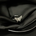 Detail view of silver butterfly ring with small diamonds and pearl on black silk - Adjustable Open / Silver Pearl Butterfly