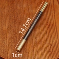 Detail view of black and gold massage bar with dimensions 14.7cm by 1cm on a wood tray - Black Golden Cudgel Pen