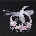 Detail eines handgefertigten Blumenstirnbands mit Perlen und Organzaband für Mädchen - Handgelenk-Corsage / Lila