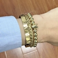 Close-up of three gold-tone stackable bracelets featuring crown charm and woven textures - Triangle Beaded Crown Gold Set