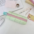 Quilted light green pencil case with pink zipper shown in a bright desk organizer setup - Green