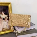 Borsa a busta in paglia intrecciata a mano con catena dorata, perle e conchiglie per mare - Bianco Sporco