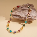 Dettaglio di una collana etnica dorata con pietre ovali in resina multicolore - Collana-Multicolore