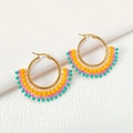 Detailed macro view of handmade seed bead earrings with colorful fan-shaped patterns - Orange