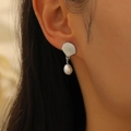 Detailed view of elegant silver shell earrings with pearls on a model side profile - Shell Pearl Style (WG0151) / Silver