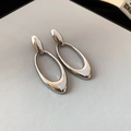 Detailansicht der silbernen ovalen geometrischen Ohrringe mit poliertem Metall-Finish - Silber