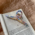 Detail of marble pattern acetate hair claw clip with gold spring on a book - Fantasy Blue