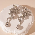 Detailed macro view of silver earrings with ribbon curves and large teardrop crystals - Silver Needle - Silver Irregular Flower Water Drop Dangle