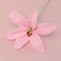 Detailed close-up of a pink hand-knitted crochet lily flower with green stem and brown stamen - Finished Lily Stems - Pink