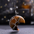 Macro shot of tiger eye moon pendant with silver wire-wrapped tree of life design - Tiger's Eye