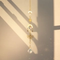 Detail of brass butterfly suncatcher with crystal ball creating rainbow light on wall - Moon Butterfly