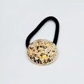Close-up of elegant gold alloy hair tie with a textured hammered metal plate on black band - Hammered Round Disc with Foil Flakes (Hair Tie 66)