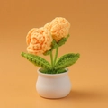Makro-Detail von handgehäkelten doppelten orangefarbenen Rosen im weißen Keramiktopf - Doppelkopf-Rosen-Topfpflanze / Gelb