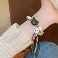 Ethnic woven bracelet with black cat and skull beads featuring tricolor fringe tassels - Cat Head Skull Ceramic Style