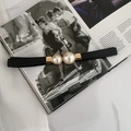 Dettaglio della fibbia dorata con perle bianche su una cintura elastica nera - Stile Semplice / Nero Perlato