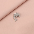 Macro shot of silver dolphin pendant with textured finish on soft pink fabric - 6# Dolphin Style