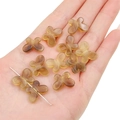 Translucent brown acrylic butterfly beads for jewelry making held in hand for size - Brown