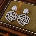 Dettaglio di orecchini a rosa in argento con zirconi su scatola di velluto verde - Orecchini Pendenti con Camelia Svuotata / Argento