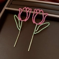 Detailaufnahme hohler Tulpenohrringe aus Metall mit funkelnden rosa und grünen Steinen - Rosa Grün Kontrast (925 Silber Stift)