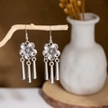 Macro shot of vintage silver flower earrings with metallic tassels on a wooden branch - E2874-15/Five-petal Flower Tassel