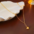 Dettaglio della collana dorata con ciondolo a cuore su un vassoio portagioie a conchiglia - Pendente Geometrico a Sfera Spazzolata (55# Collana-Oro-Placcatura in Oro Vero)