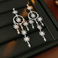 Makro-Detail von silbernen Blumen-Ohrringen mit Zirkon-Inlay und Dreamcatcher-Design - Silber