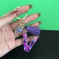 Letter V resin keychain with purple glitter, stones, fringe tassel and gold hardware - Letter V