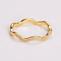 Macro shot of gold wave-shaped ring with pavé-set clear zircons on a white background - US 5 / Gold