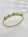 Golden geometric bracelet with pavé crystal discs and pyramid studs on white background - Bangle-Two-tone