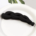 Matte black twist banana hair clip with secure inner teeth on white porcelain plate - Black