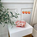 Transparent peach print PVC makeup bag with pink zipper on a white bedside table - Pink Peach