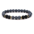 Detail of beaded bracelet with blue turquoise, matte onyx, and gold spacers on white background - Blue Crack Stone
