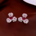 Macro-opname van zilveren bloemoorringen met rode zirkoon en witte pavé details - Bloem Oorknopjes (Paars) / Zilver/Paars