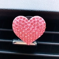 Close-up of pink heart-shaped car air vent clip with sparkling rhinestones decoration - Pink