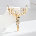 Golden reindeer brooch with white crystals and marquise-cut stones on white pedestal - Golden Reindeer Style
