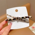 Leopard print bow hair clip on a white card shown in a stylish closeup - Leopard Leather Bobby Pin