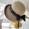 Beige woven straw sun hat featuring a black wide ribbon bow on a golden display stand - M(56-58cm) / Khaki