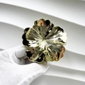 Détail d'une pince à cheveux fleur dorée avec finition métallique tenue dans un gant blanc - Camélia / Or