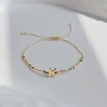 Detailaufnahme des bunten Perlenarmbands mit goldenem Buchstaben-Anhänger K - Buchstabe K
