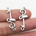 Silver musical note pendants for DIY jewelry making shown in hand on white background - Music Note (12x31mm-1.6g)