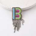 Detail einer Regenbogen-Buchstabe B Brosche mit hängenden Strass-Fransen auf Weiß - Buchstabe B