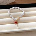 Bracelet en perles chic avec chaîne dorée et pendentif rond en émail rouge vif - Grenade